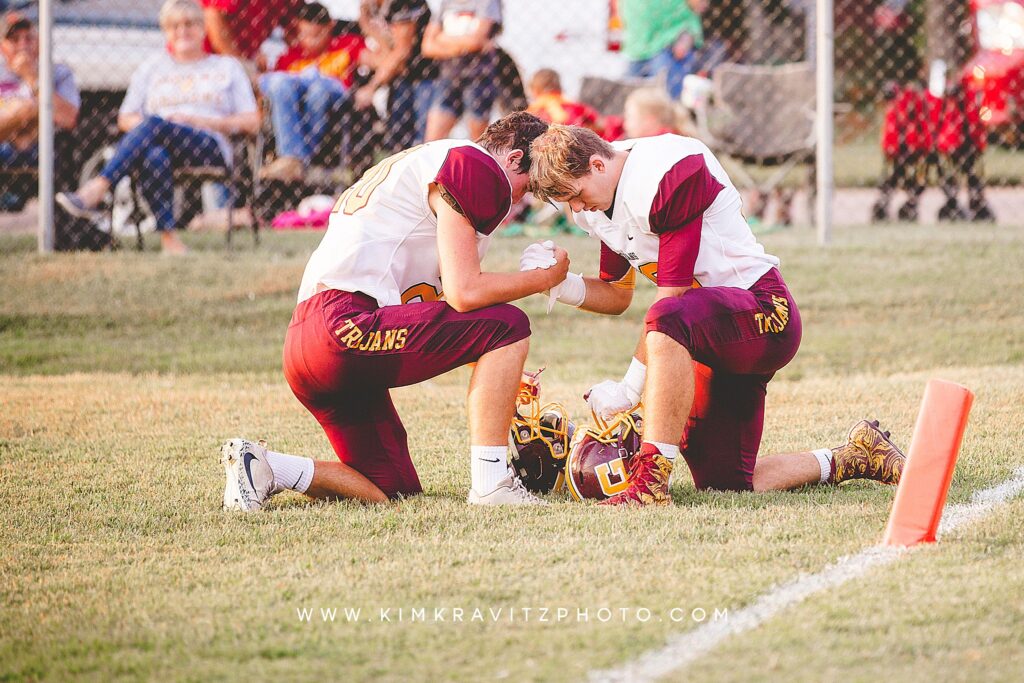 football players praying on the field